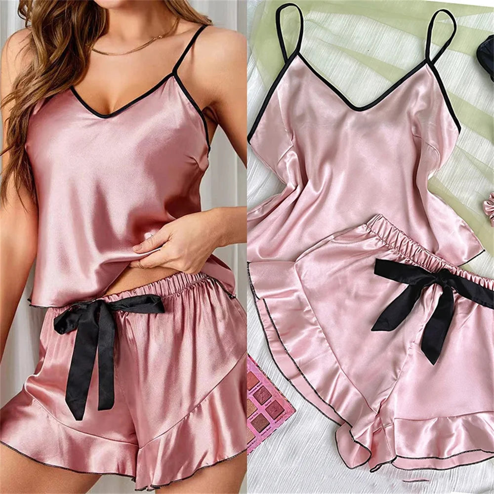 Pink satin pajama set with black ribbons on a white background