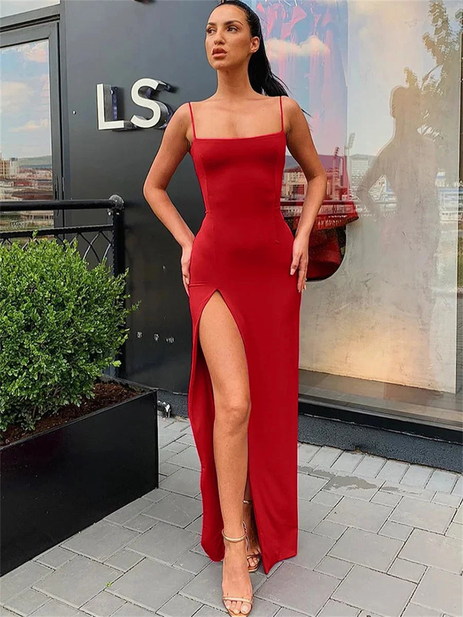 Woman in a red dress standing on a rooftop with a cityscape background
