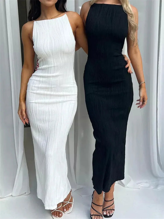 Two women wearing a white and a black sleeveless dress against a white curtain background.